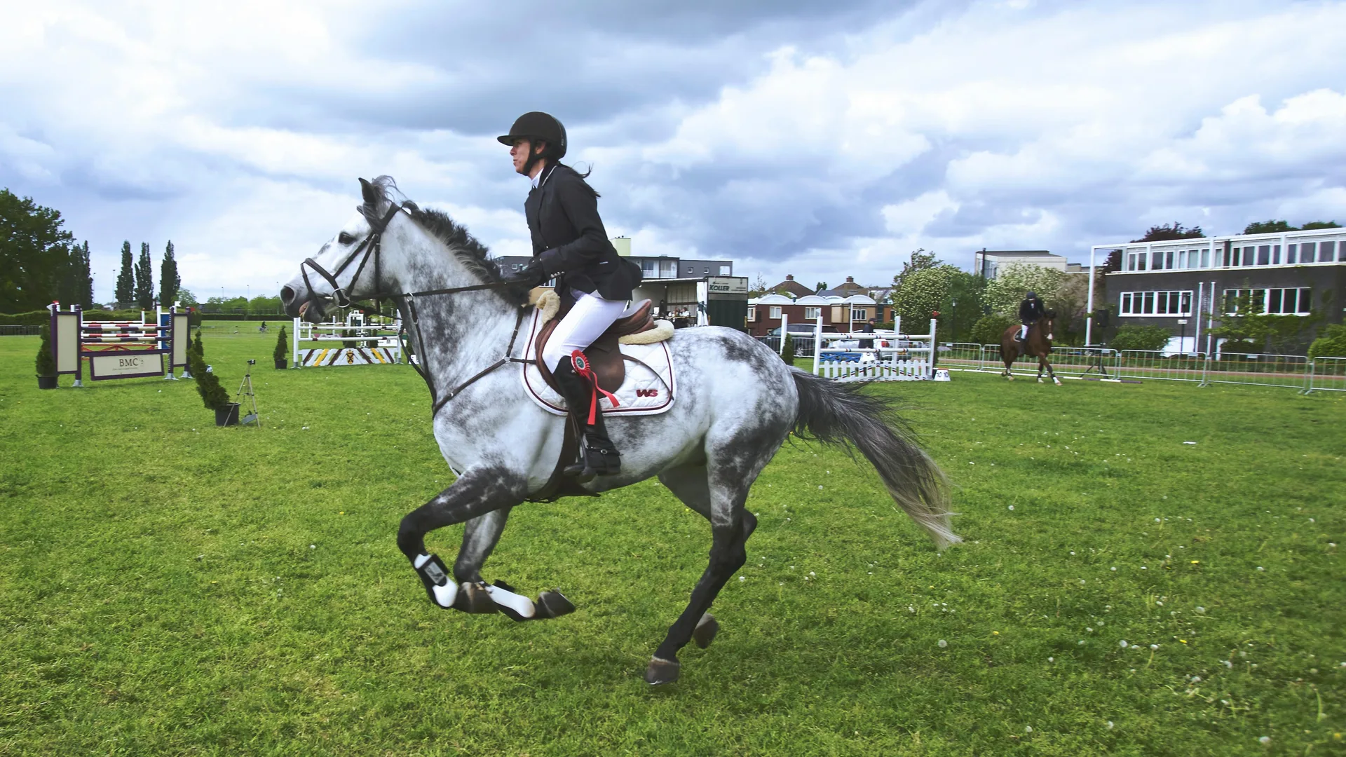 Horse and rider cantering at a show jumping event