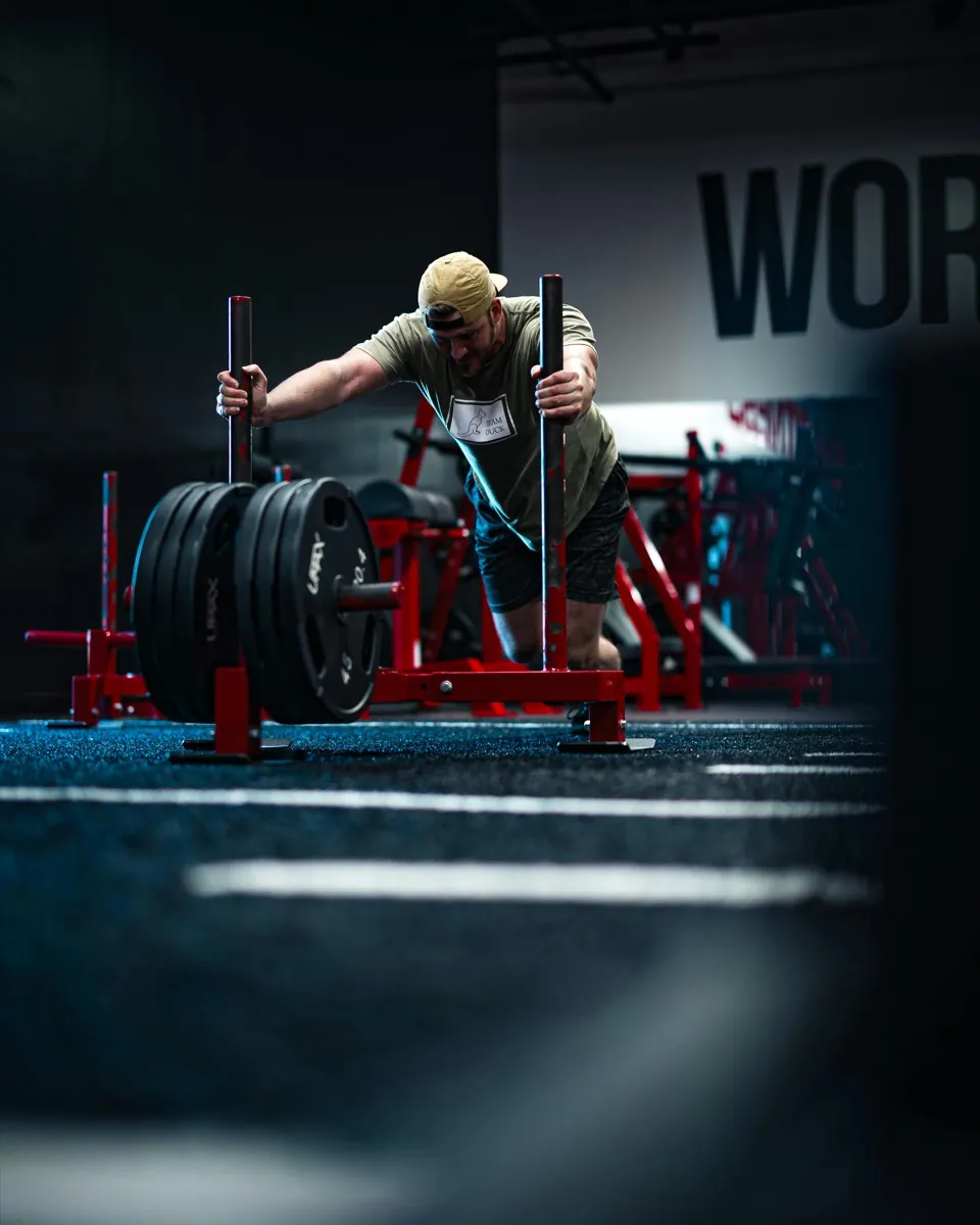 Athlete pushing a sled during a HYROX competition