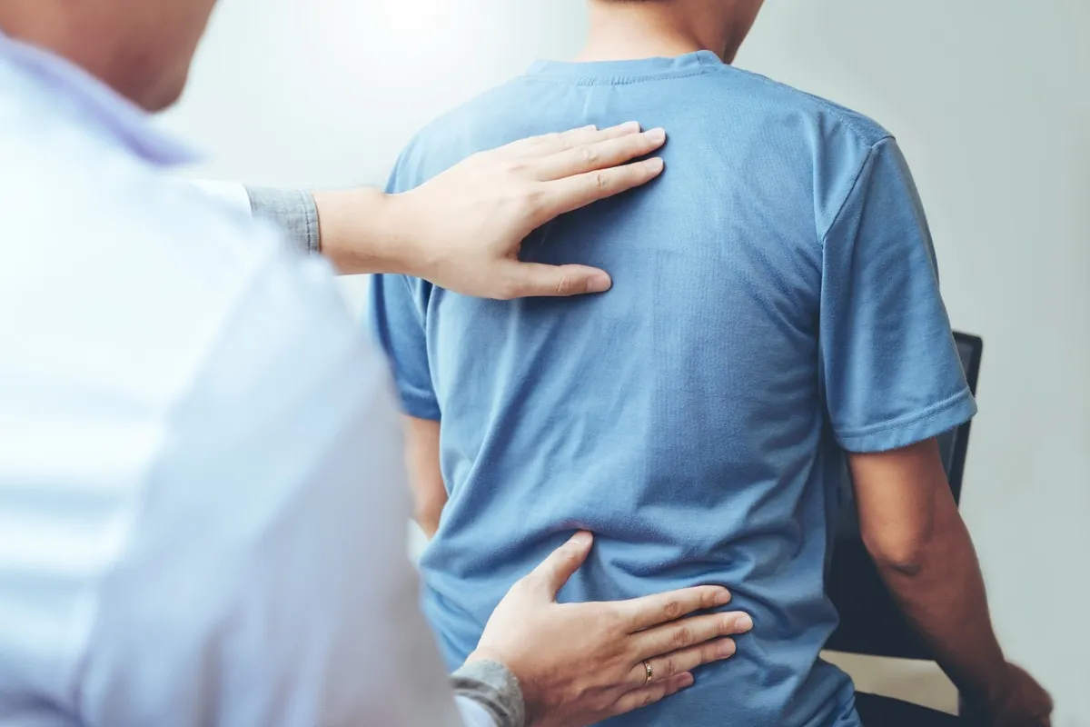Chiropractor performing a spinal assessment on a patient during a maintenance care visit