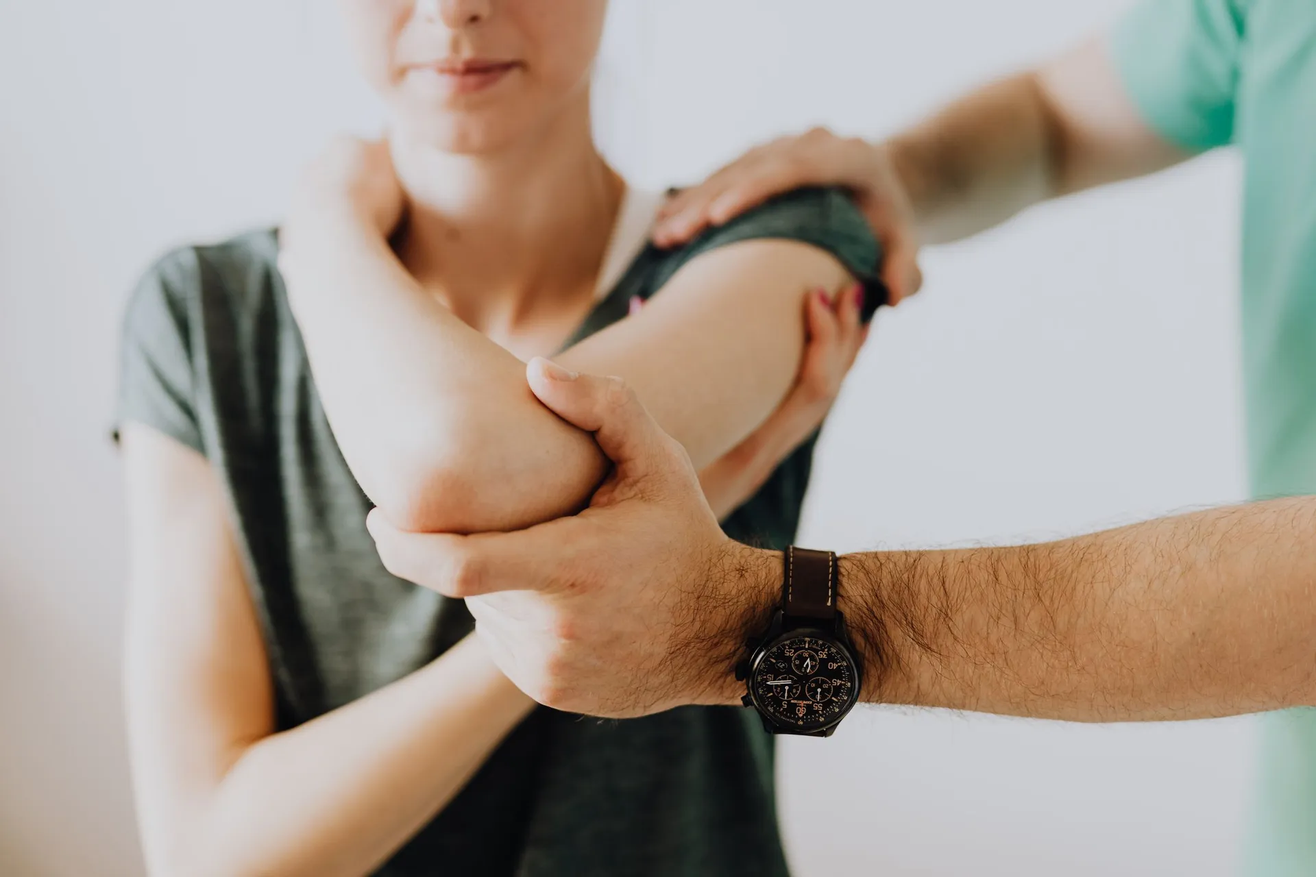 Chiropractor assessing a woman's shoulder and elbow movement