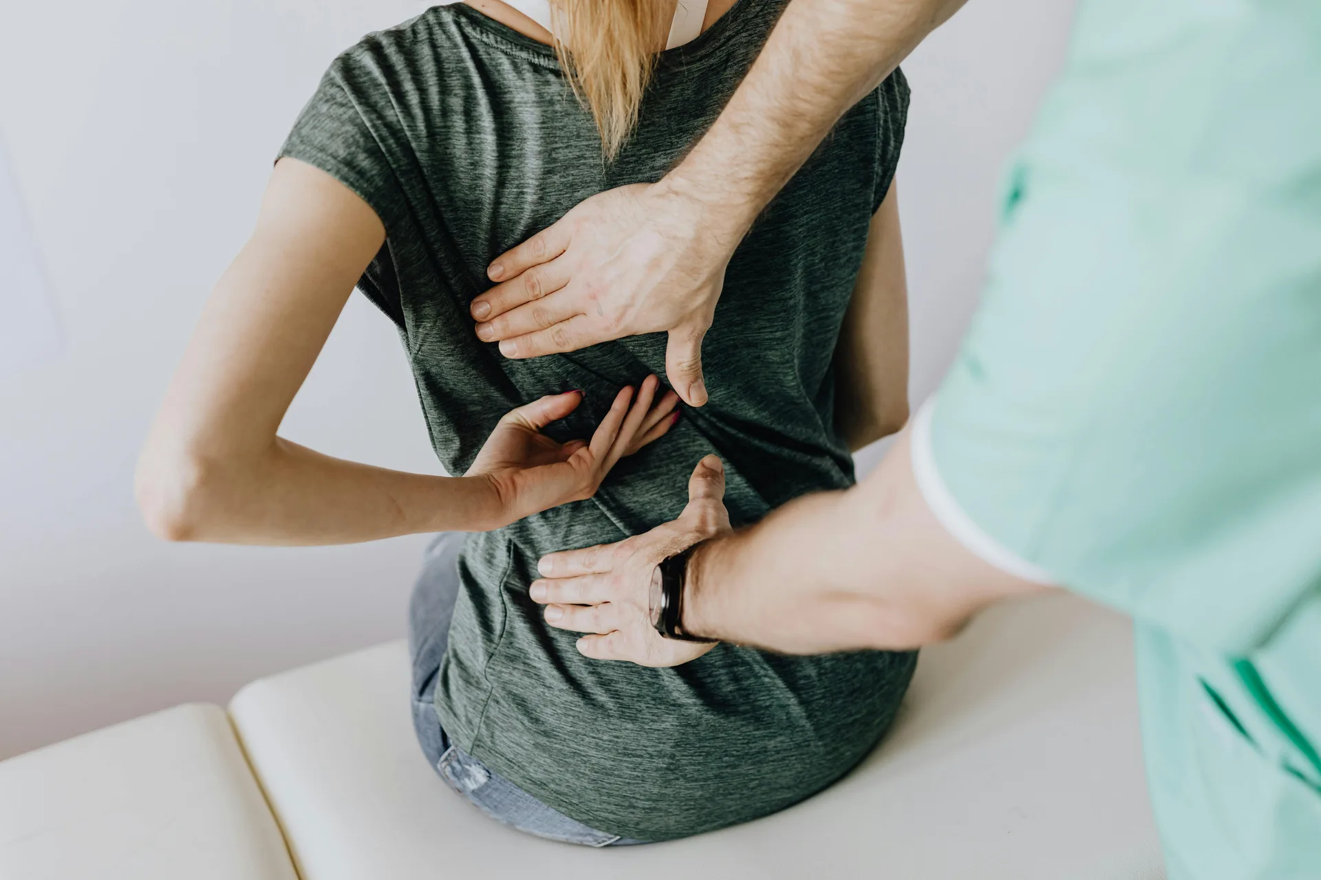 Chiropractor examining a patient's lower back for sciatica